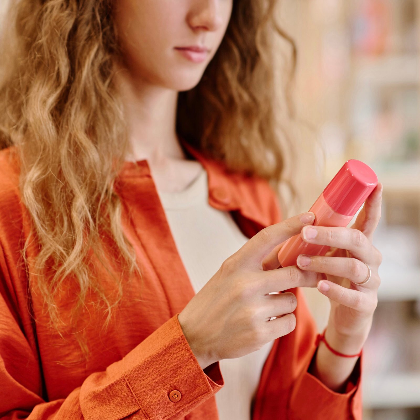 Woman reading label on cosmetic bottle